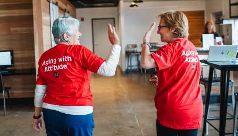two women in volunteer t shirts high fiving each other