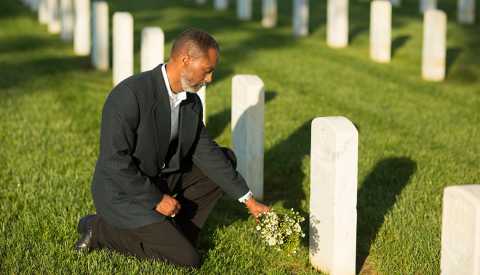 widower kneeling at gravesite widower kneeling at gravesite