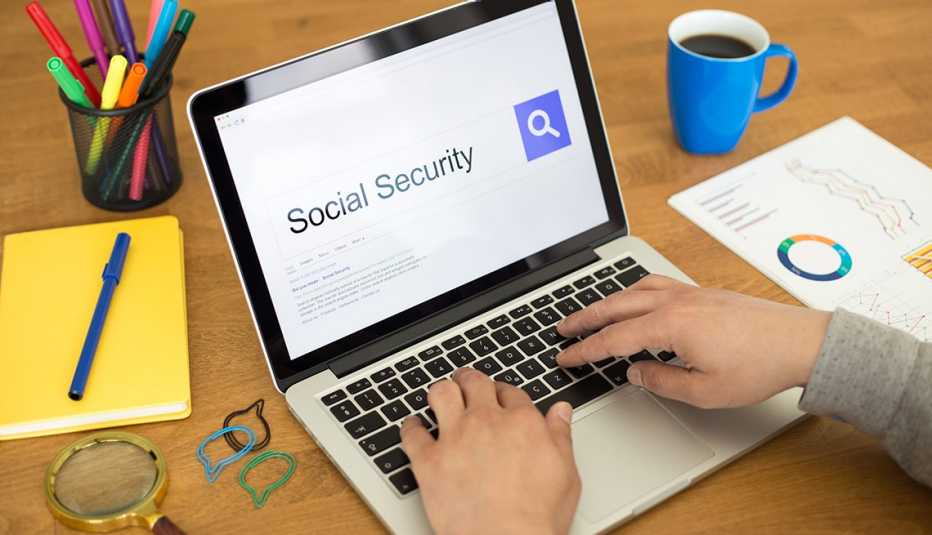 persons hands typing on laptop keyboard showing an internet search for social security