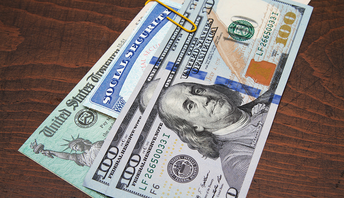 Money, social security card and check sitting on table