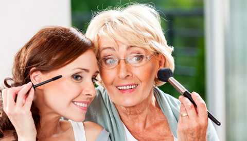 A mother and daughter applying their makeup together