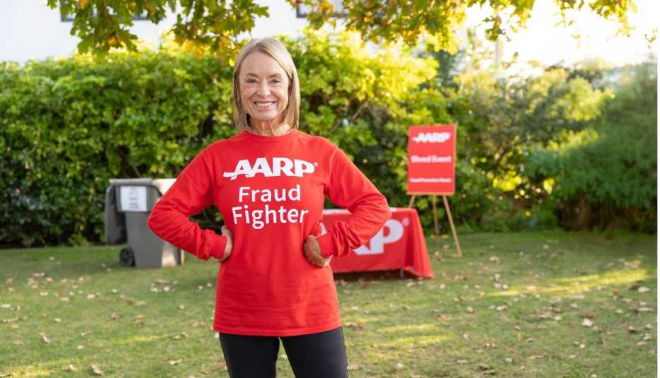 Woman standing outside wearing an AARP Fraud Fighter t-shirt