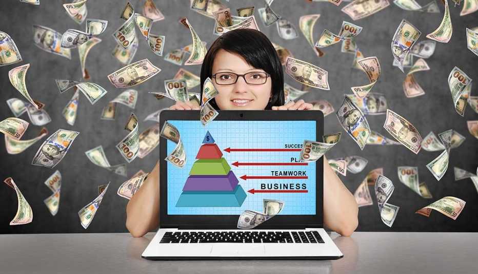 Mujer con una computadora y billetes de 100 dólares volando detrás de ella.