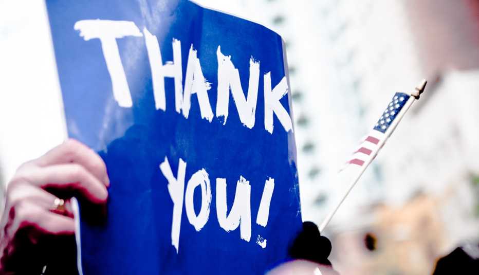 a blue sign that says thank you with a small american flag next to it