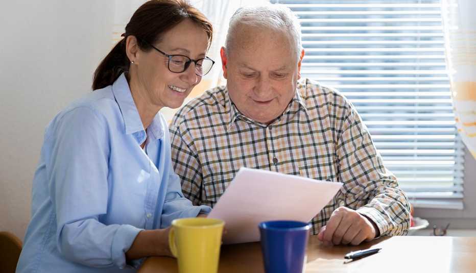 Una cuidadora lee un documento junto a la persona que cuida.