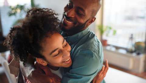 father hugging teen daughter
