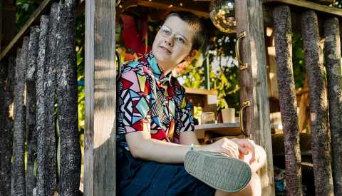 teenager sitting in a tree house