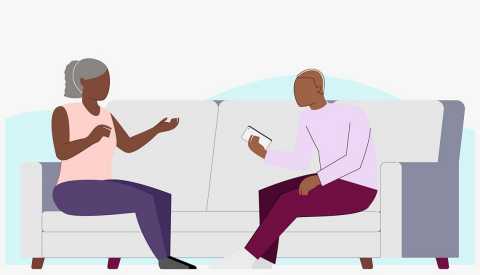 Mom and teen son sitting on a couch talking