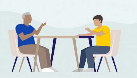 two people sitting at a table talking
