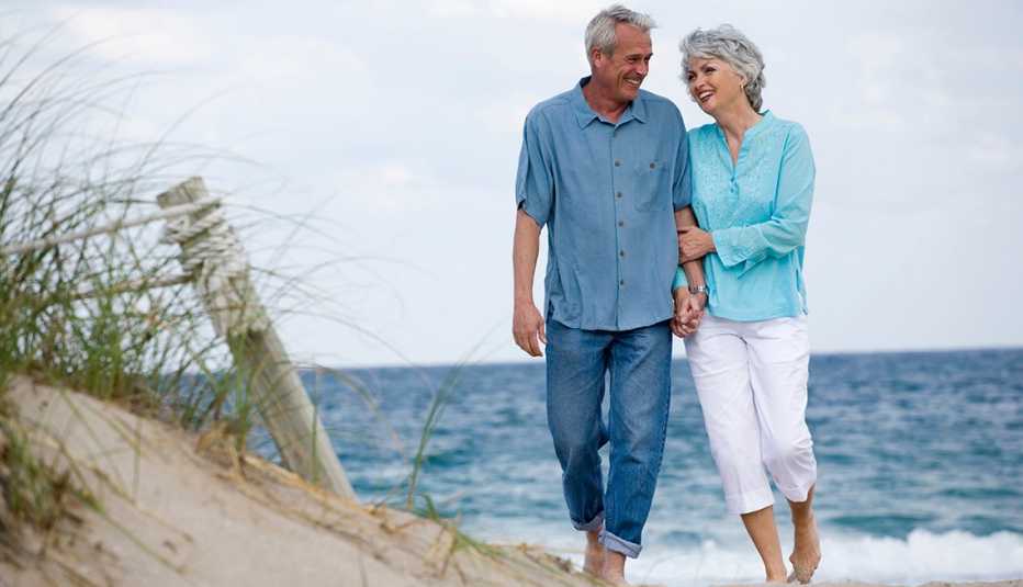 A couple walking arm in arm on a beach in Florida