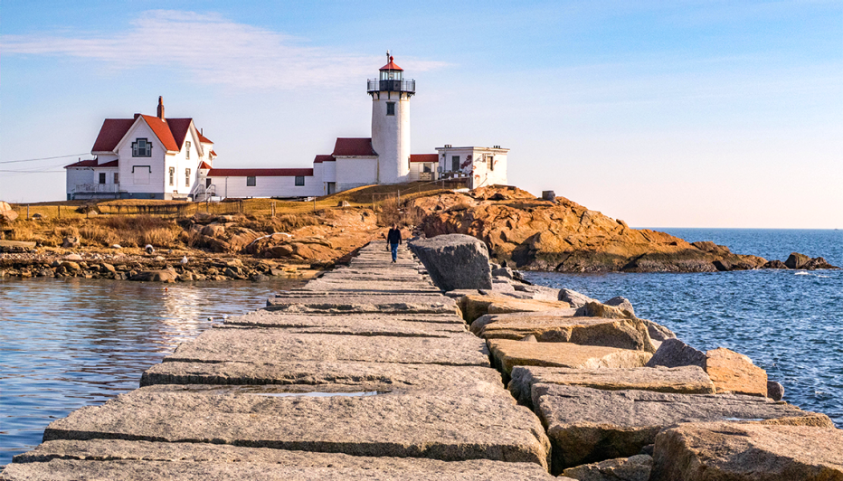 a man walking to the eastern point lighthouse in gloucester massachusetts