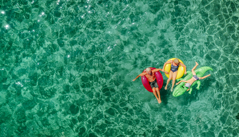 Two people sitting on tubes and one on a raft in water overhead look at two people sitting on tubes and one on a raft in water