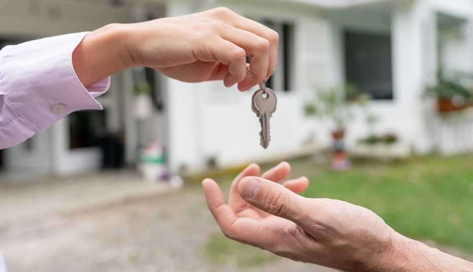 two hands one holding a set of keys over another and dropping them off to the hand underneath