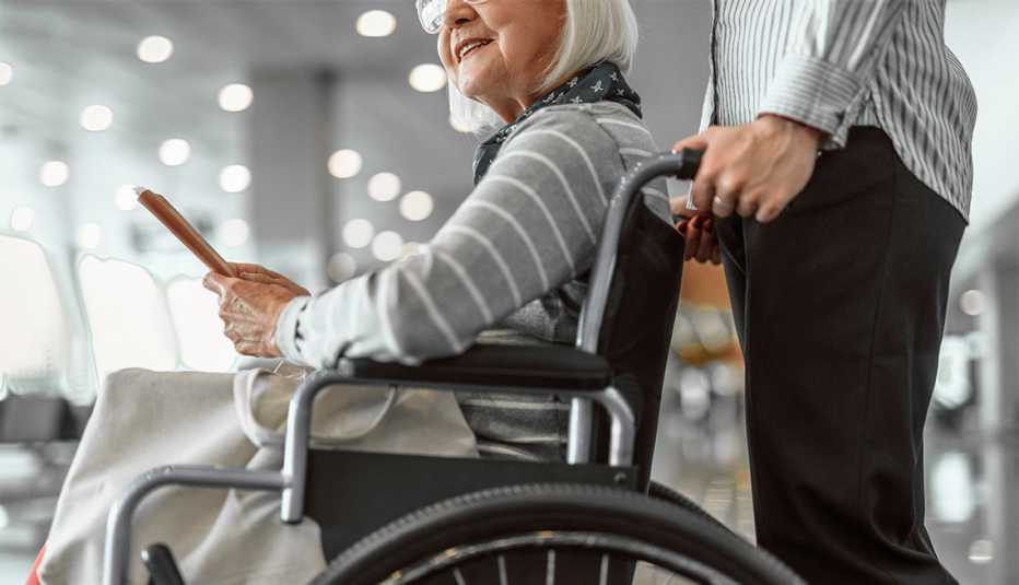 Airport female officer helping for female passenger in a wheelchair