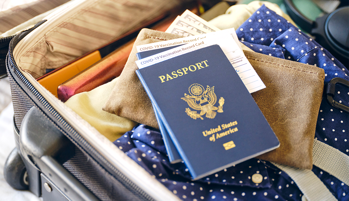 a suitcase ready for travel with passports and covid vaccination cards