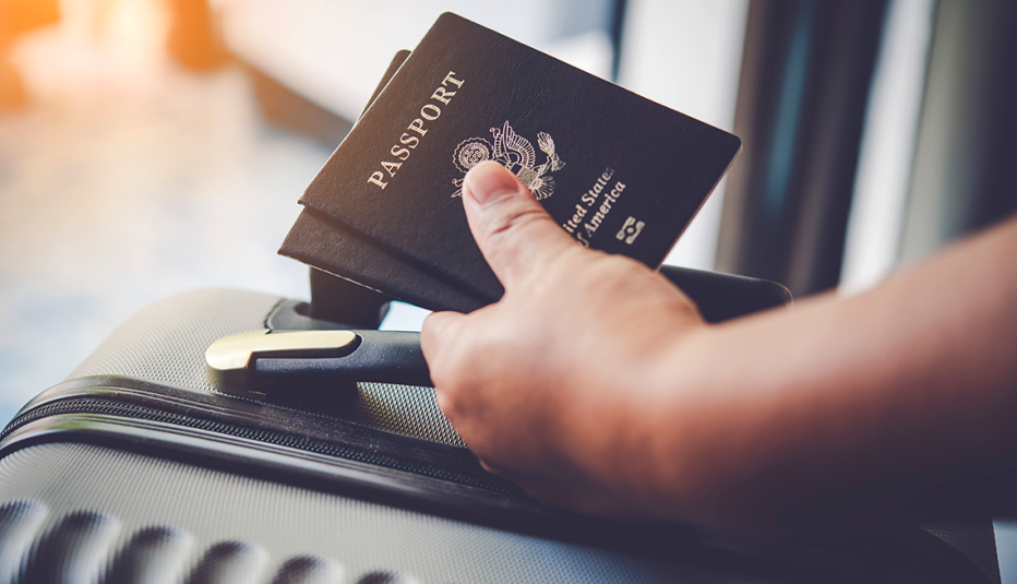 hand holding luggage and passports