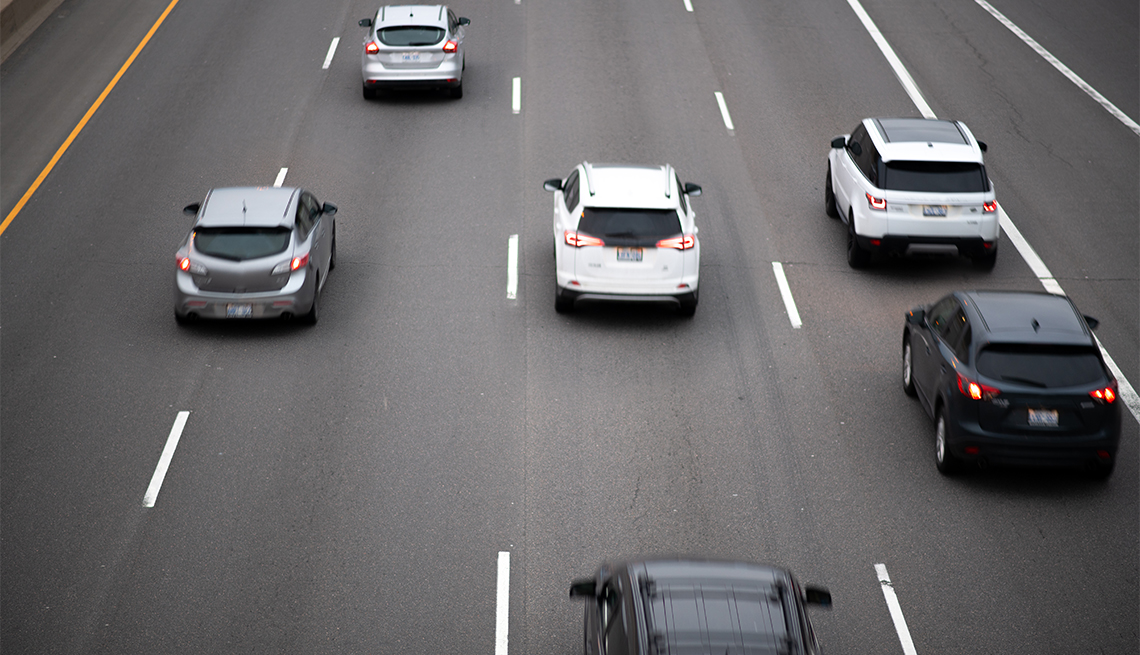 Cars travel in a pack on a major highway / interstate.