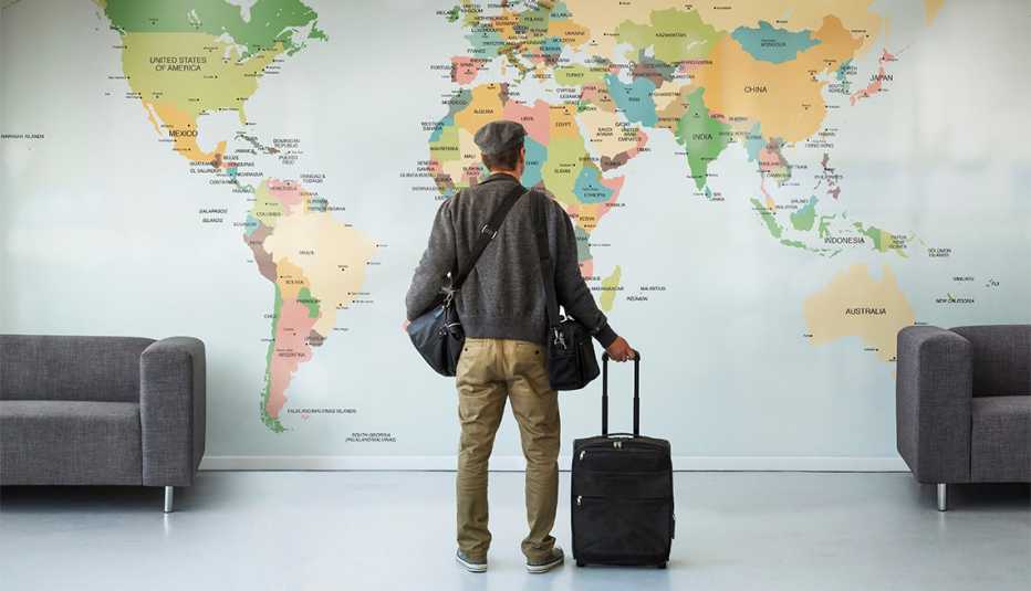 man looking at map of the world on a wall