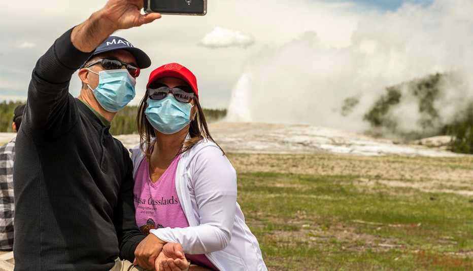 a couple takes a selfie as Old Faithful