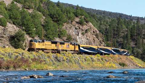 rocky mountaineer train driving past a mountain and a river rocky mountaineer train driving past a mountain and a river