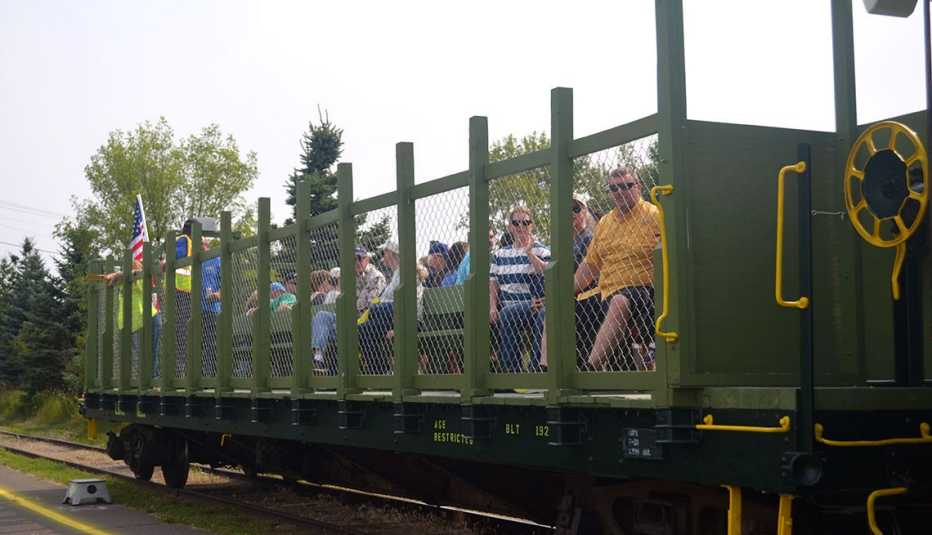 passengers sitting in an open-air car on the lake superior and mississippi railroad