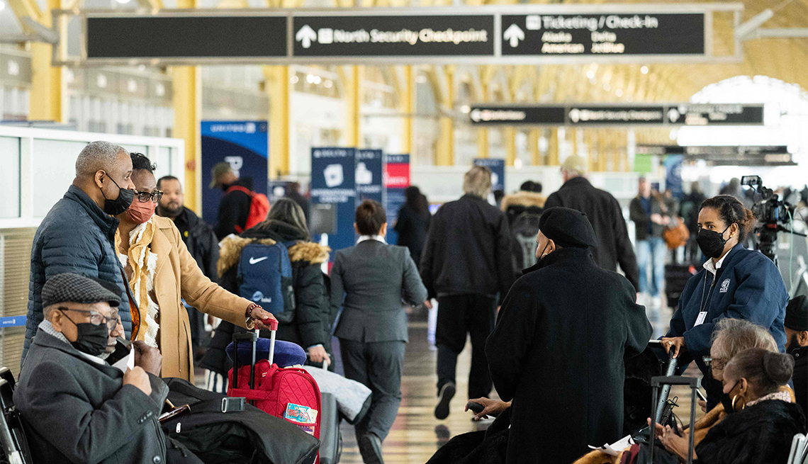 Travelers at Reagan National Airport wait in the terminal for their flights as cancelled and delayed flights mount due to an FAA outage that grounded flights.