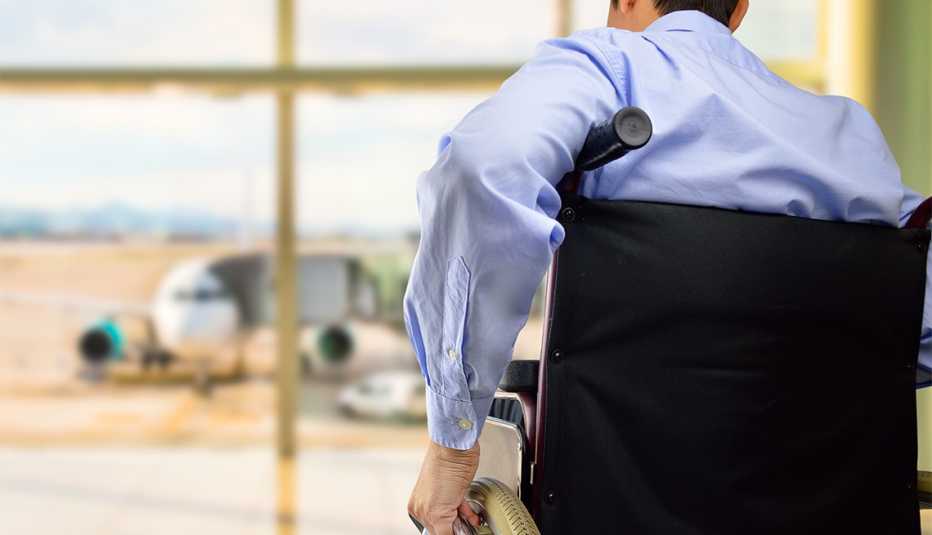 rear view of a business man in wheelchair at the airport with focus on hand