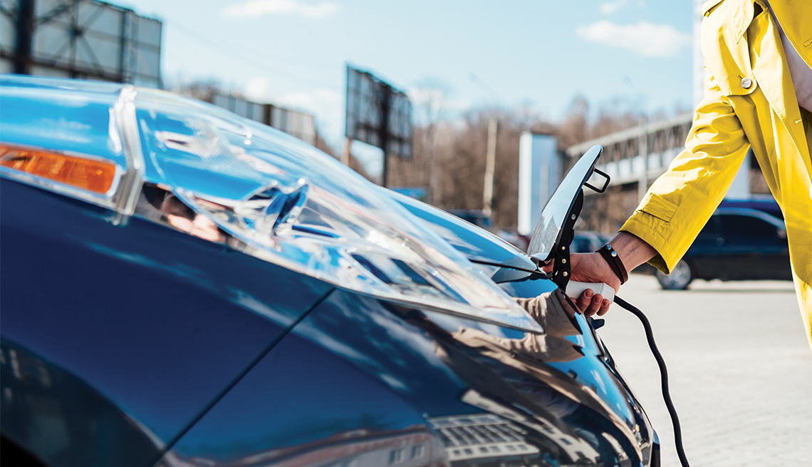 a man disconnects the charging cable from an electric car