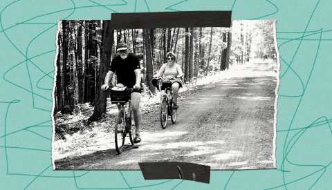 teal border with squiggly lines surrounds a black and white image of a man and woman riding bicycles on black diamond trail lined with trees teal border with squiggly lines surrounds a black and white image of a man and woman riding bicycles on black diamond trail lined with trees