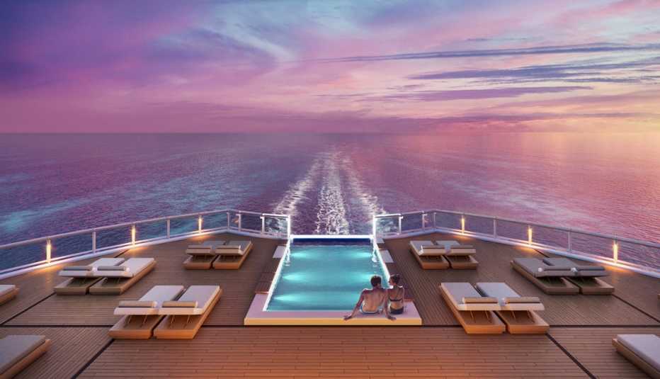 couple in a pool on the back of a cruise ship at sunset