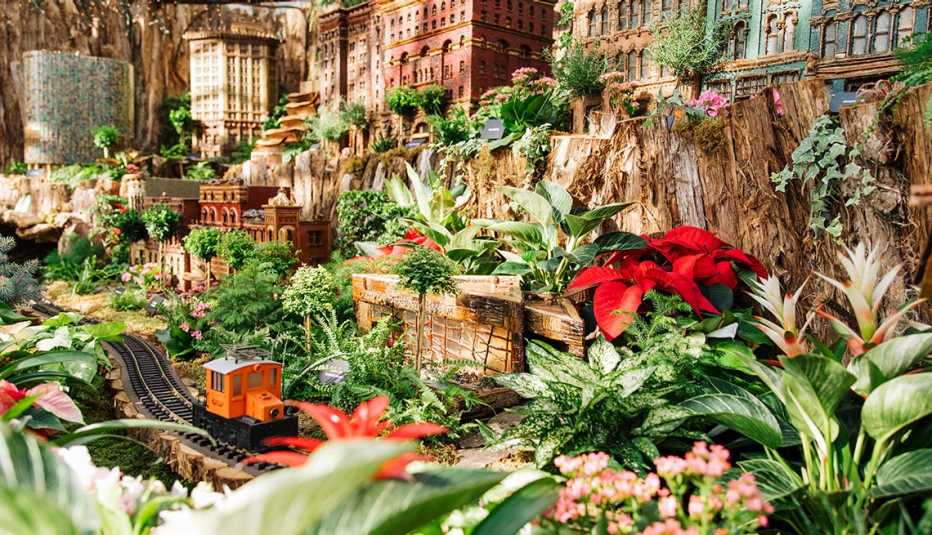 model trains pass by buildings and tropical plants in the frederik meijer gardens and sculpture park