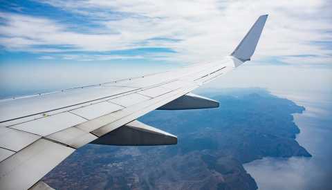 airplane wing over clouds