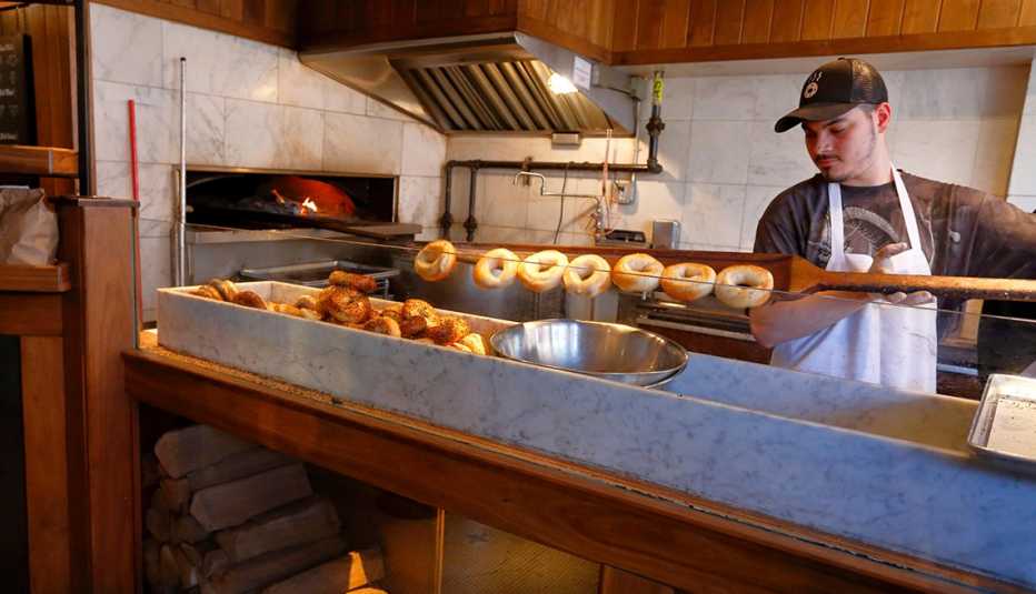 man making bagels in kitchen of bagel shop