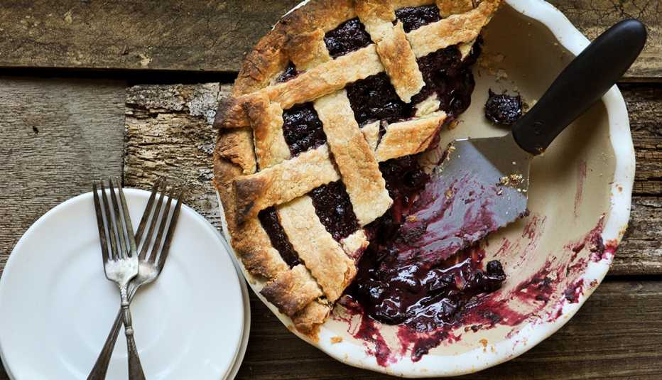 Top horizontal shot of lattice topped pie on stone pie plate on wood background