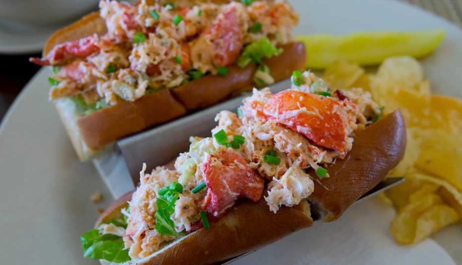 two lobster rolls with a side of chips