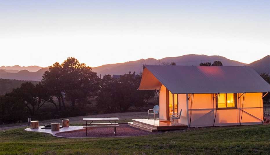 A Royal Gorge Cabin with lights on during sunset