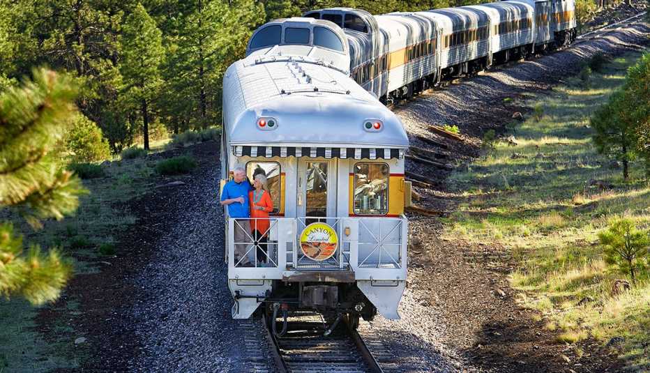passengers stand outside a luxury car in the back of the grand canyon railway in arizona