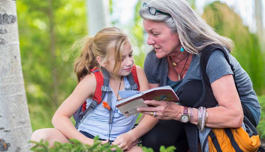 a grandmother showing her granddaughter a national park guidebook