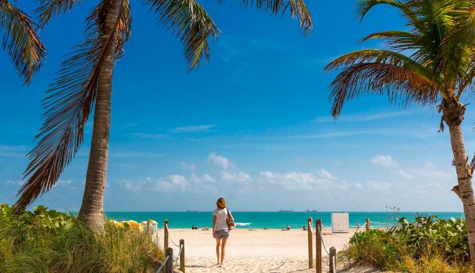 woman walking onto the beach in south beach miami florida