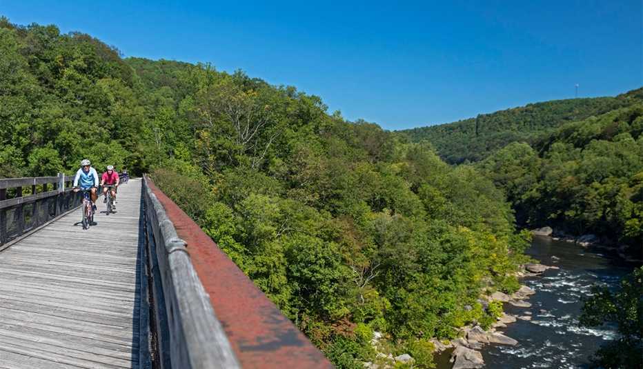 Bicycle riders cross a bridge over the Youghiogheny River on the Great Allegheny Passage trail 