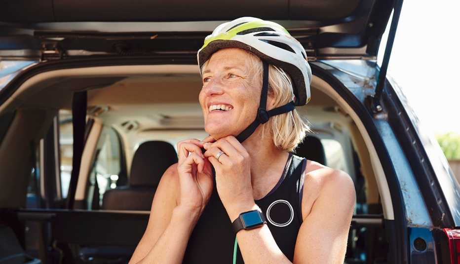 Woman putting on her bike helmet.