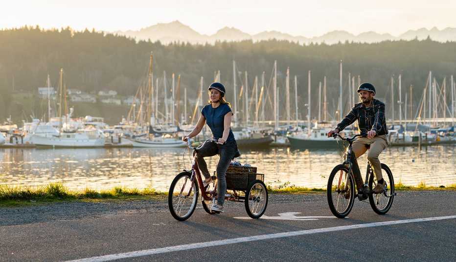 two people riding the tristar burg and vida bikes along a pretty harbor