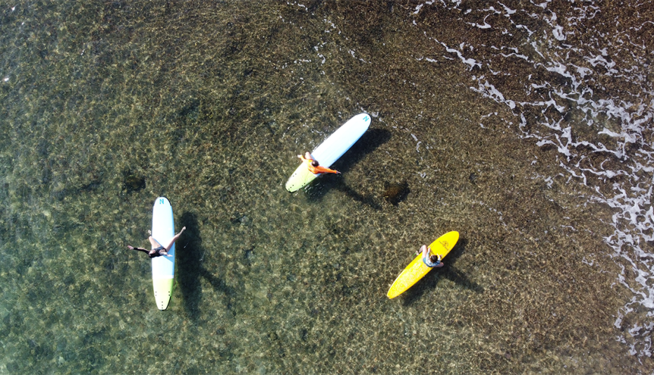 surfers in the water at pata sudaka surf camp in oahu hawaii