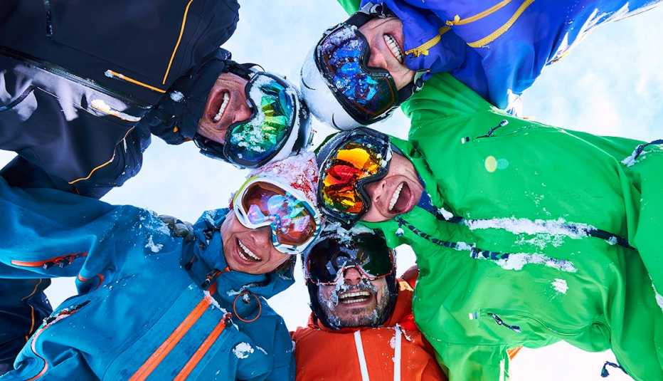 a group of five male skiers huddled together