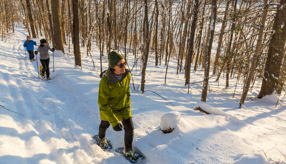 people snow shoeing in a snowy forest