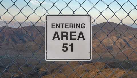 Entering Area 51 sign on a fence at The Military Base in Nevada desert at sunset Entering Area 51 sign on a fence at The Military Base in Nevada desert at sunset