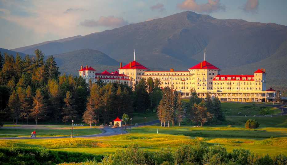 beautiful old hotel with white walls and red roof in a picturesque mountain setting