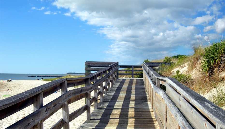 Wooden dock, with late afternoon shadows, partition off sand dunes from Cape Charles Beach on the Island of Assateague, Virginia.