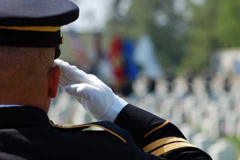 Army soldier renders salute at cemetery