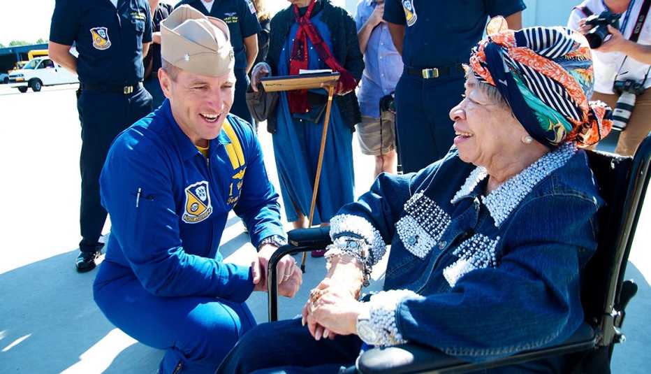 a man is talking with a woman in a wheelchair